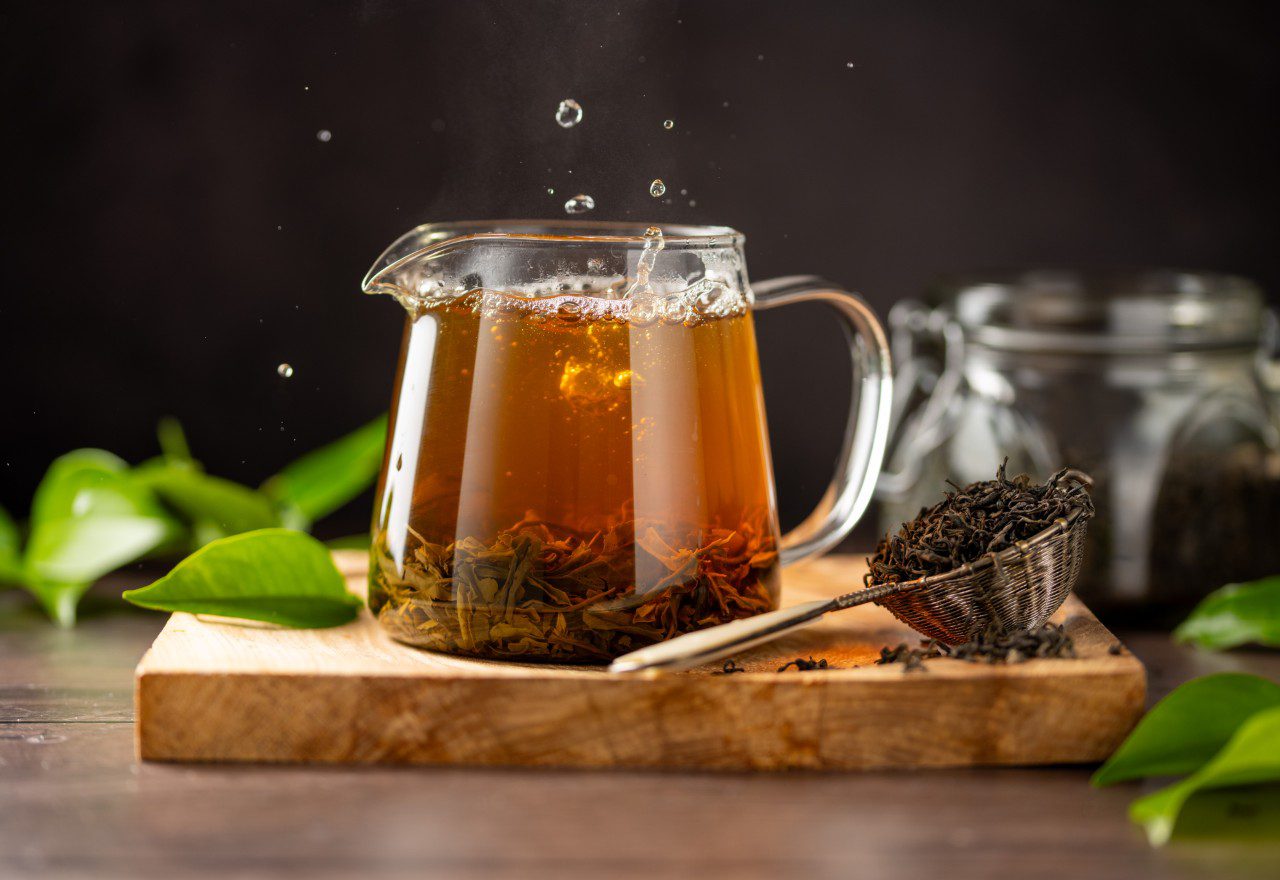 Glass teapot with brewing tea leaves